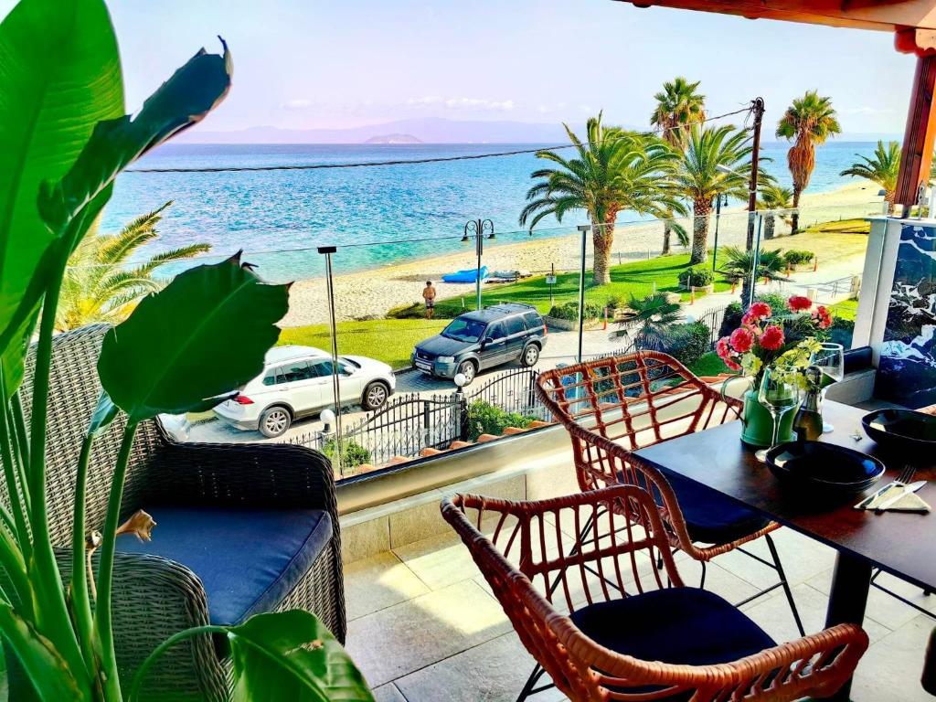 balkon ze stołem i krzesłami oraz widokiem na ocean w obiekcie Lux Suite Sea Front Avra w mieście Pefkochori