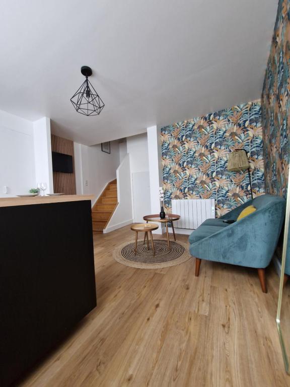 坎佩尔Le Cottage的客厅里有一张蓝色的沙发和一张桌子