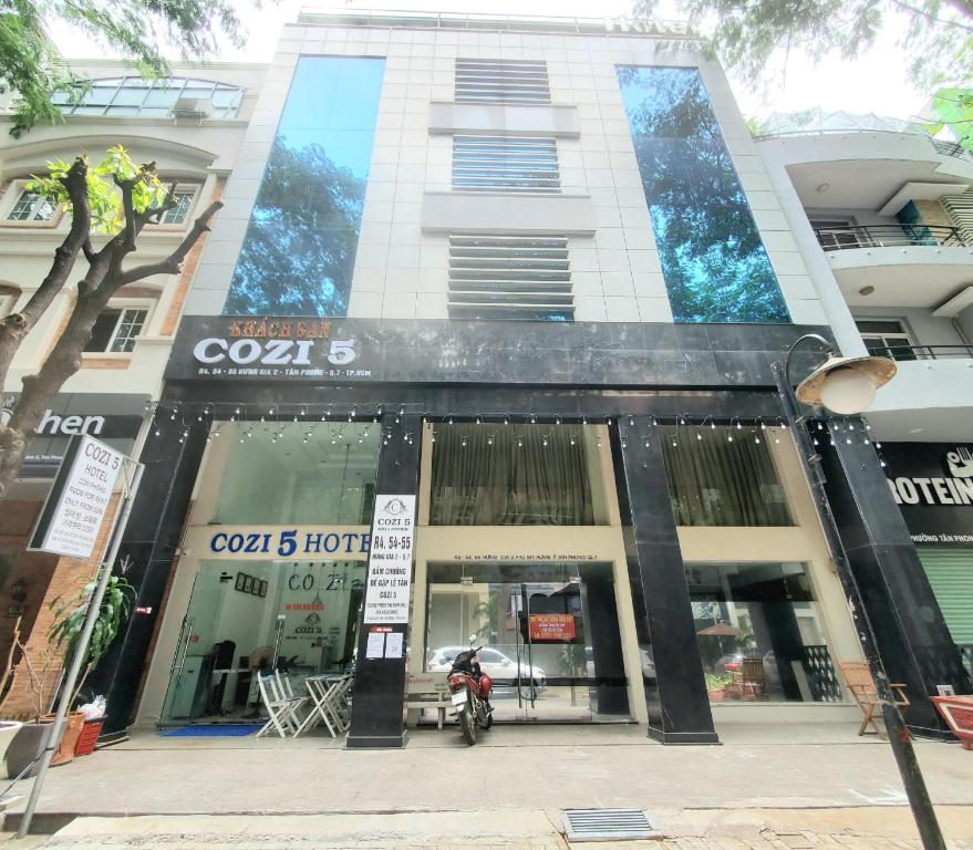 胡志明市的住宿－Cozi 5 Serviced Apartment，停在大楼前的摩托车