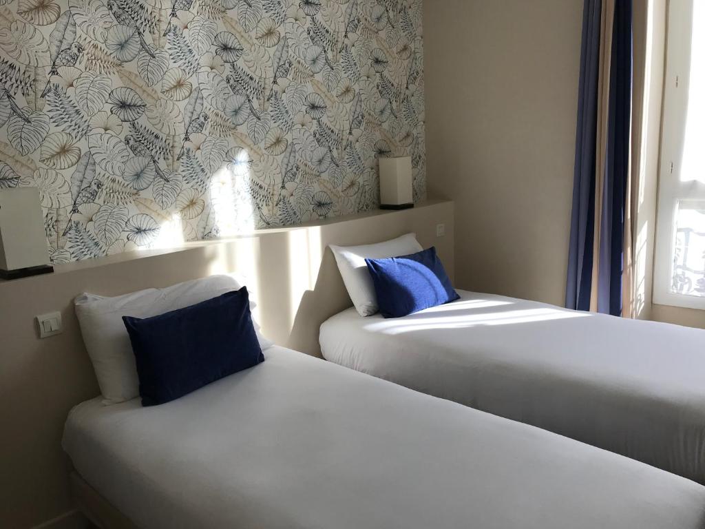 two beds sitting next to each other in a room at Hotel Le Havre Bleu in Beaulieu-sur-Mer