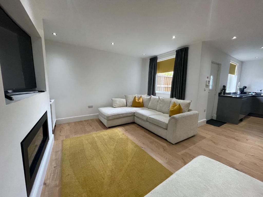 a living room with a couch and a flat screen tv at Holdsworth House Apartments in Killingbeck