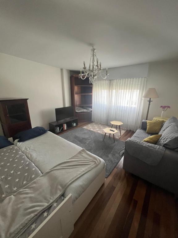 a bedroom with a bed and a couch at Apartamento DENTRO DE MURALLA y PARKING GRATUITO en pleno centro in Lugo