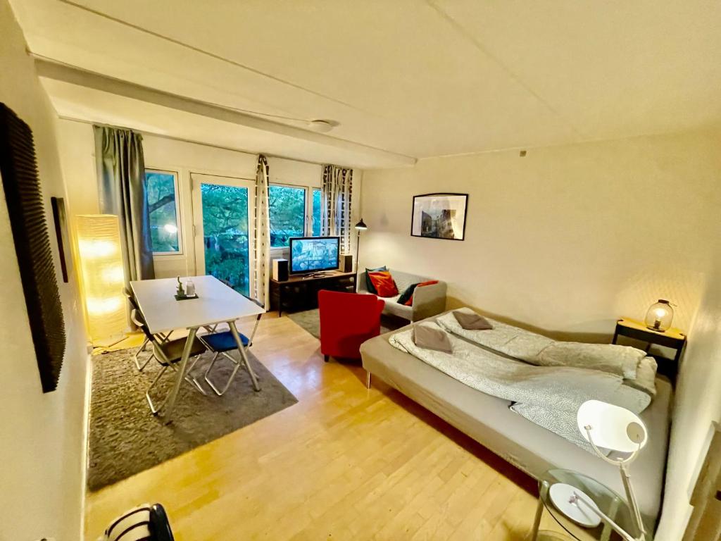 a bedroom with a bed and a living room with a table at Whole Apartment 20 minutes from the city center in Søborg
