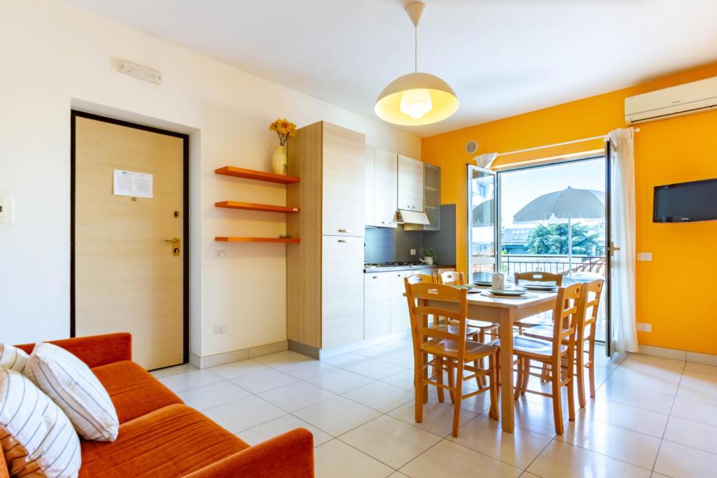 cocina y comedor con mesa y sillas en Appartamento Minerva int5 - MyHo Casa en Tortoreto