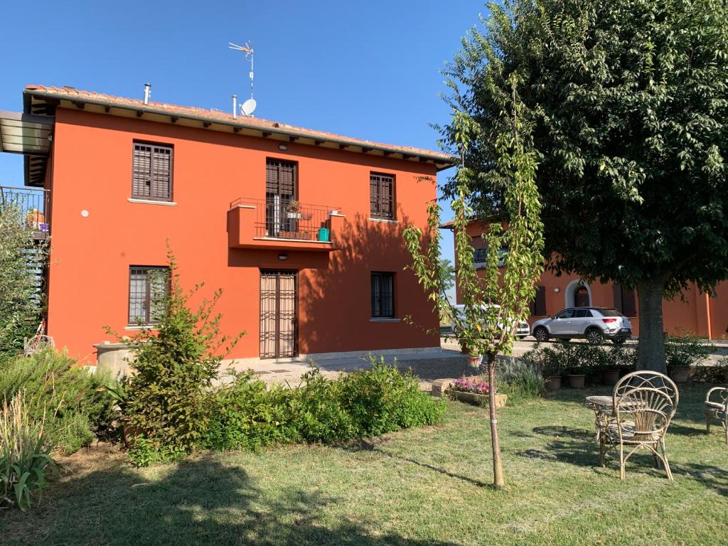 an orange house with a table and chairs in a yard at Al sit ed Marino in Castel Maggiore