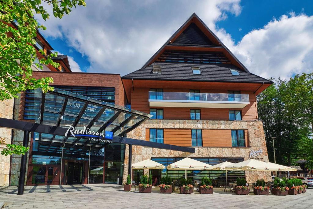 a hotel with umbrellas in front of a building at Radisson Blu Hotel & Residences in Zakopane