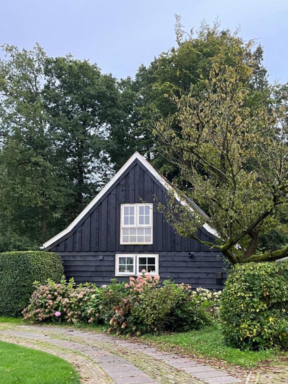 Czarna stodoła z białym oknem. w obiekcie Ruime vakantiewoning in de natuur w mieście Olst