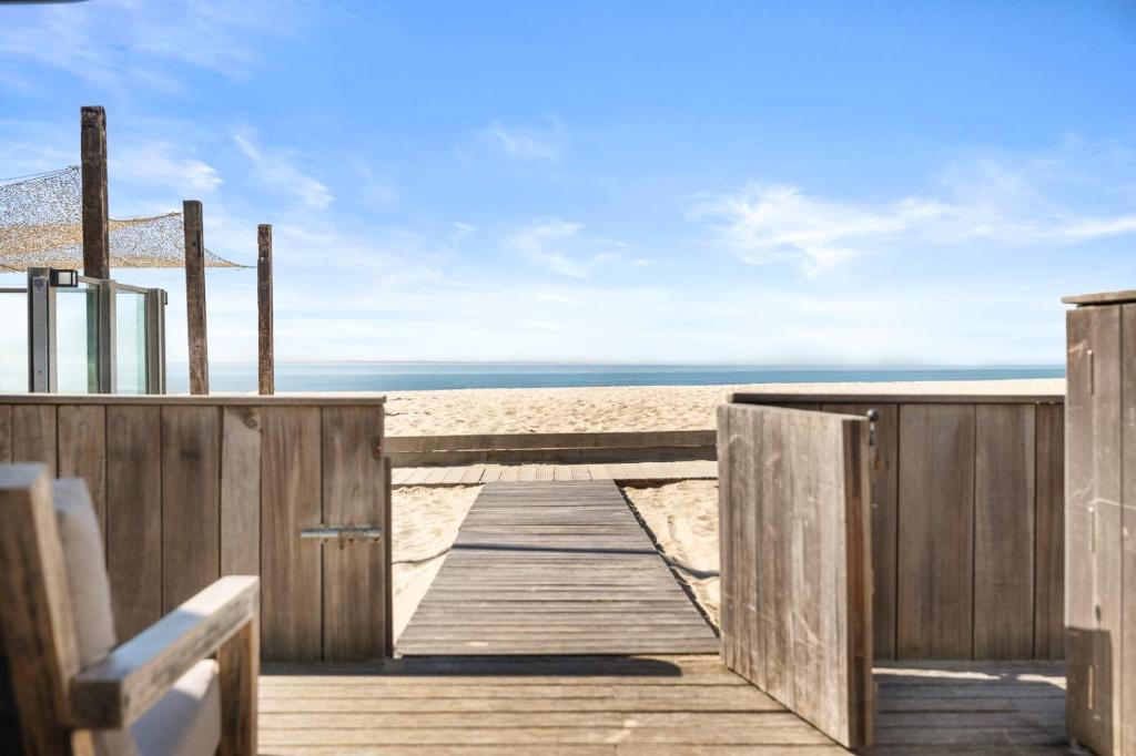 een houten promenade die naar het strand leidt bij Beachrooms Pier 7 in Vlissingen