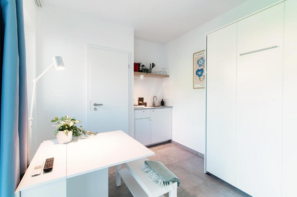 un ufficio bianco con una scrivania bianca e una porta di Le Betulle Studios by Quokka 360 - studio apartments by the Origlio lake a Origlio