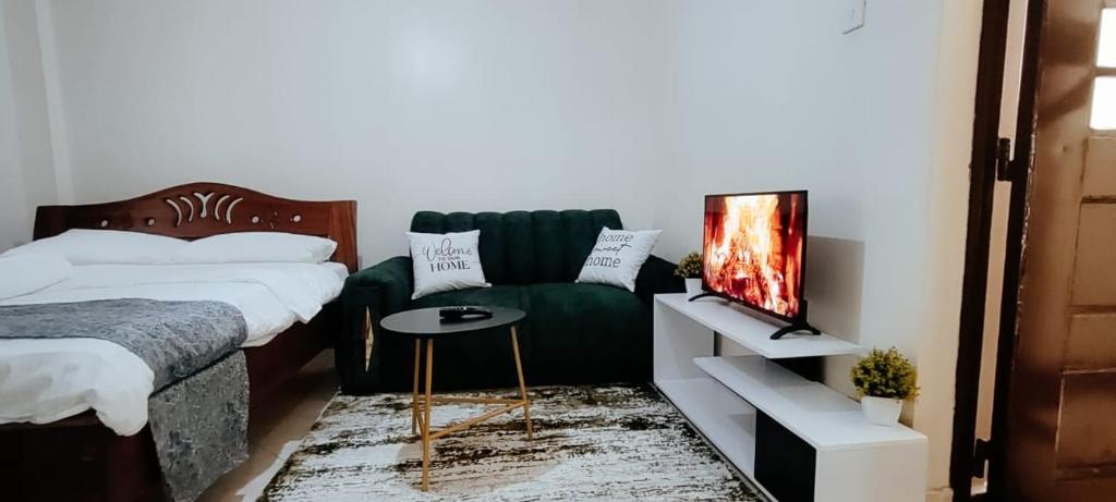 una camera con letto e divano verde di Premier Stays Ruiru a Ruiru