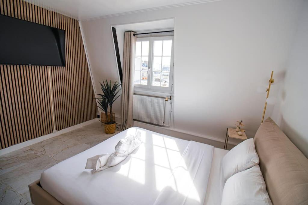 a bedroom with a bed and a couch and a window at Typical Parisian Studio in Le Marais in Paris