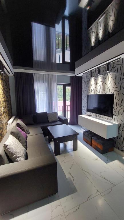 a living room with a couch and a tv at New apartments in borjomi in Borjomi