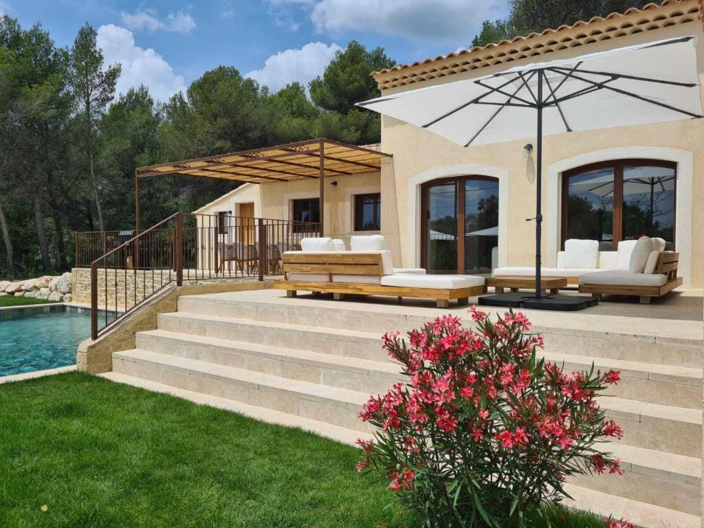 - une terrasse avec bancs et parasol à côté de la piscine dans l'établissement Villa de luxe en Luberon - Piscine chauffée, à Puget