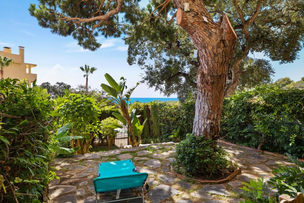 zwei blaue Stühle neben einem Baum in der Unterkunft Seaview with private garden 5 minutes walk to the beach and amenities in Sitio de Calahonda