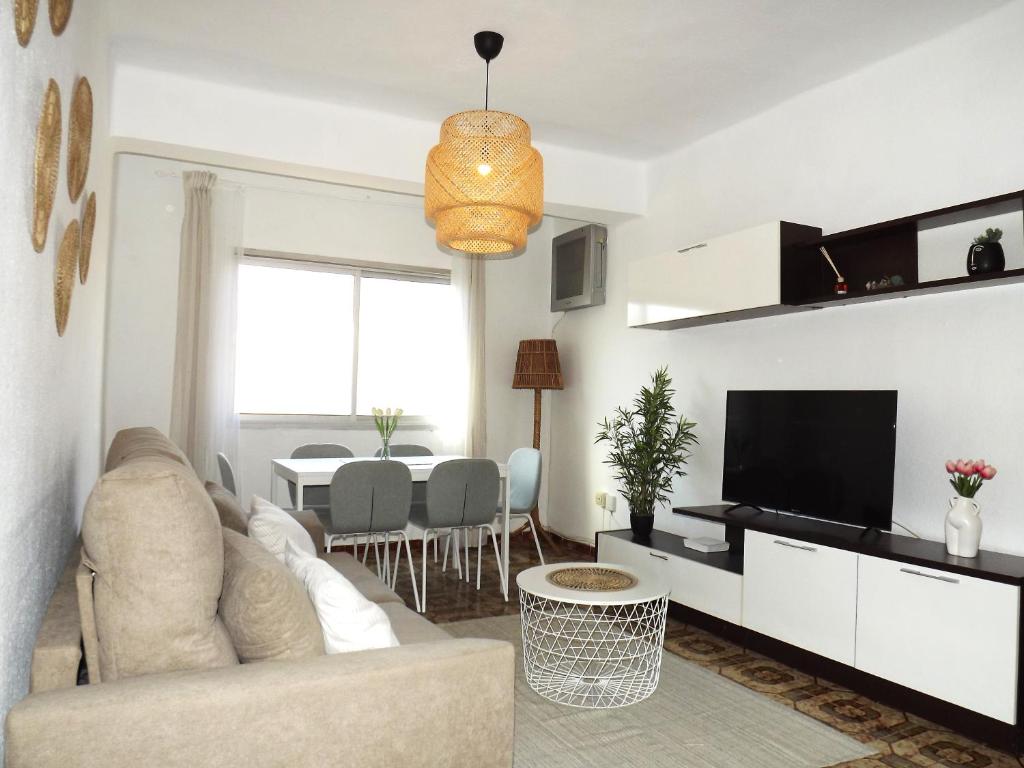 H&H Suite Plaza de Toros في غرناطة: غرفة معيشة مع أريكة وتلفزيون