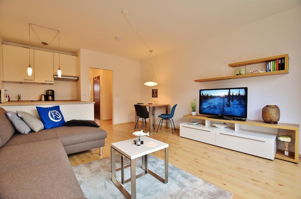 達默的住宿－FeWo "Lütt Möw"，带沙发、电视和桌子的客厅