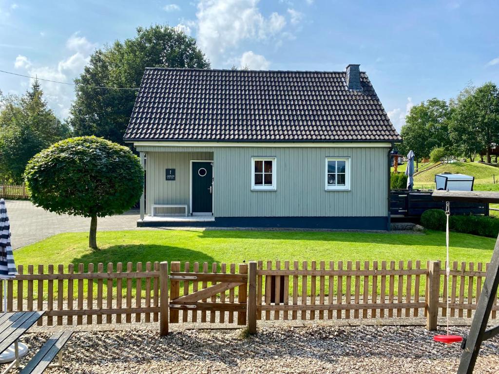 a small house in a yard with a wooden fence at Landurlaub in Schmallenberg Landhäuschen in Schmallenberg