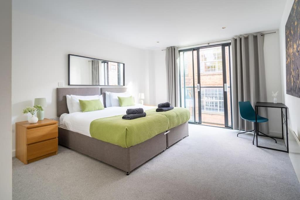 a bedroom with a large bed and a large window at The Zenith: Your Urban Oasis in Leicester
