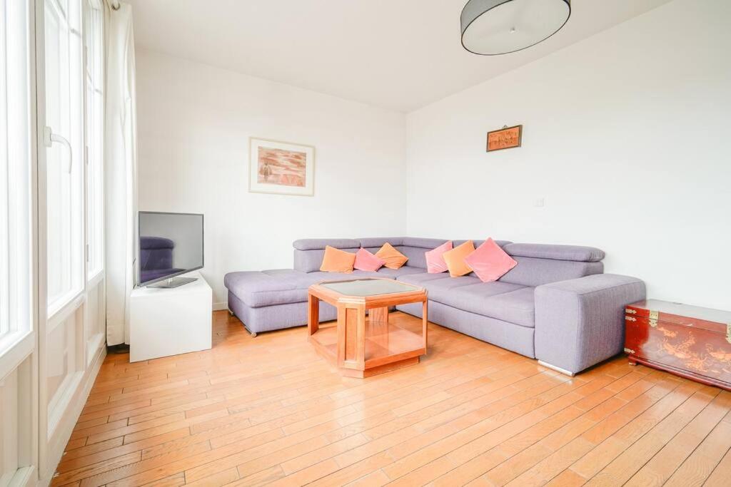 a living room with a couch and a table at Appartement spacieux 17ème arrondissement - II in Paris