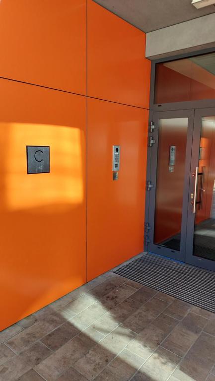an orange wall with a door in a building at Apartament Centrum, miejsce parkingowe w cenie in Warsaw
