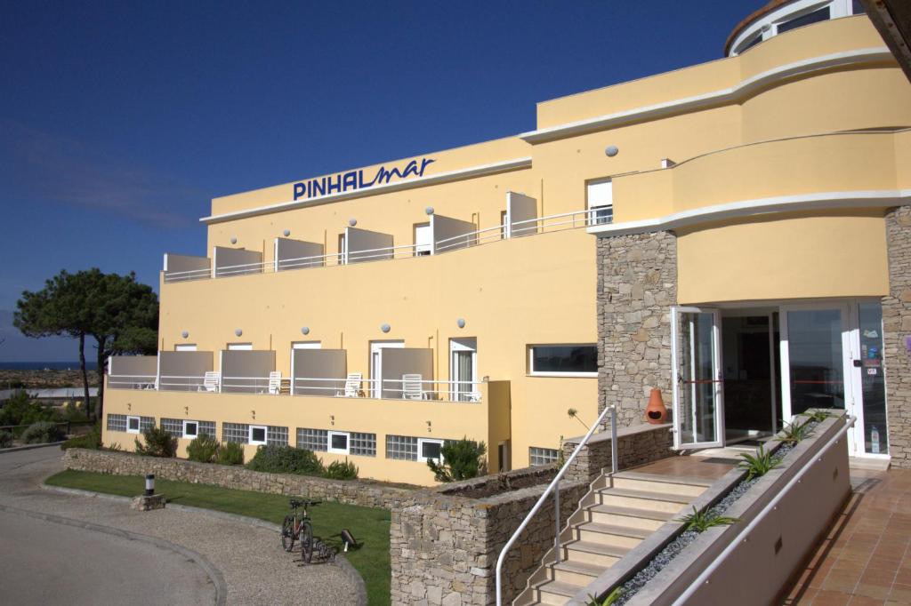 un gran edificio amarillo con un cartel. en WOT Peniche PinhalMar, en Peniche