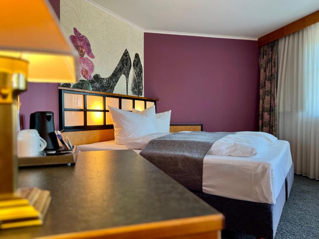 a hotel room with a bed and a purple wall at Hotel Residenz in Bad Neustadt an der Saale