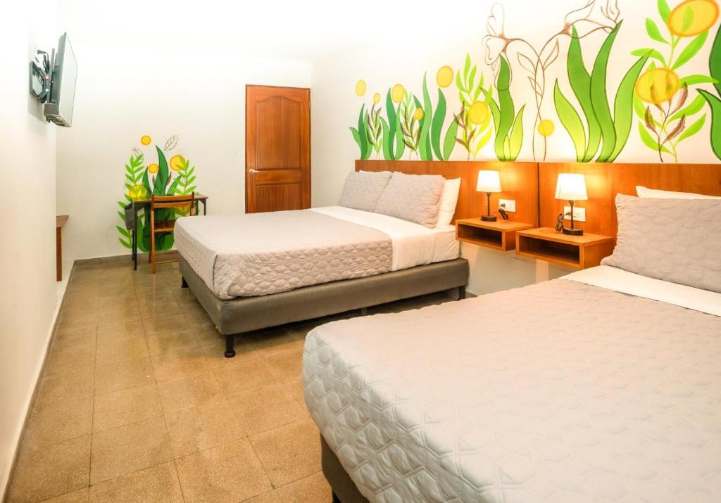 una camera con due letti e un dipinto sul muro di Hotel Caracas a Città di Panama