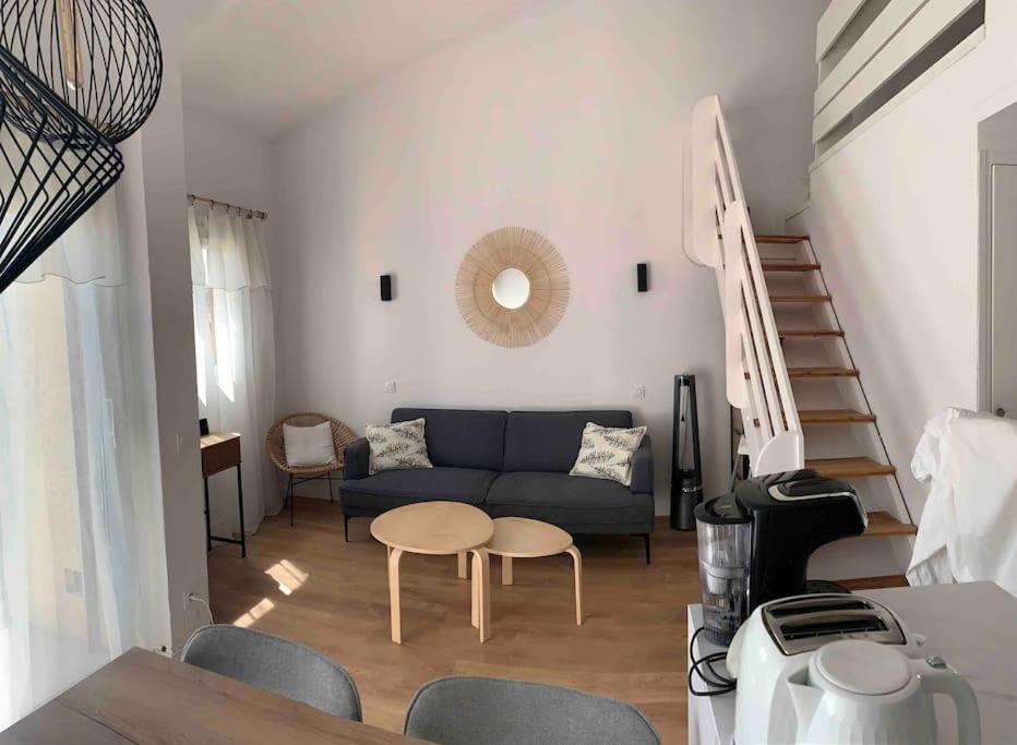 ein Wohnzimmer mit einem blauen Sofa und einem Tisch in der Unterkunft Appartement duplex Porticcio avec parking in Porticcio