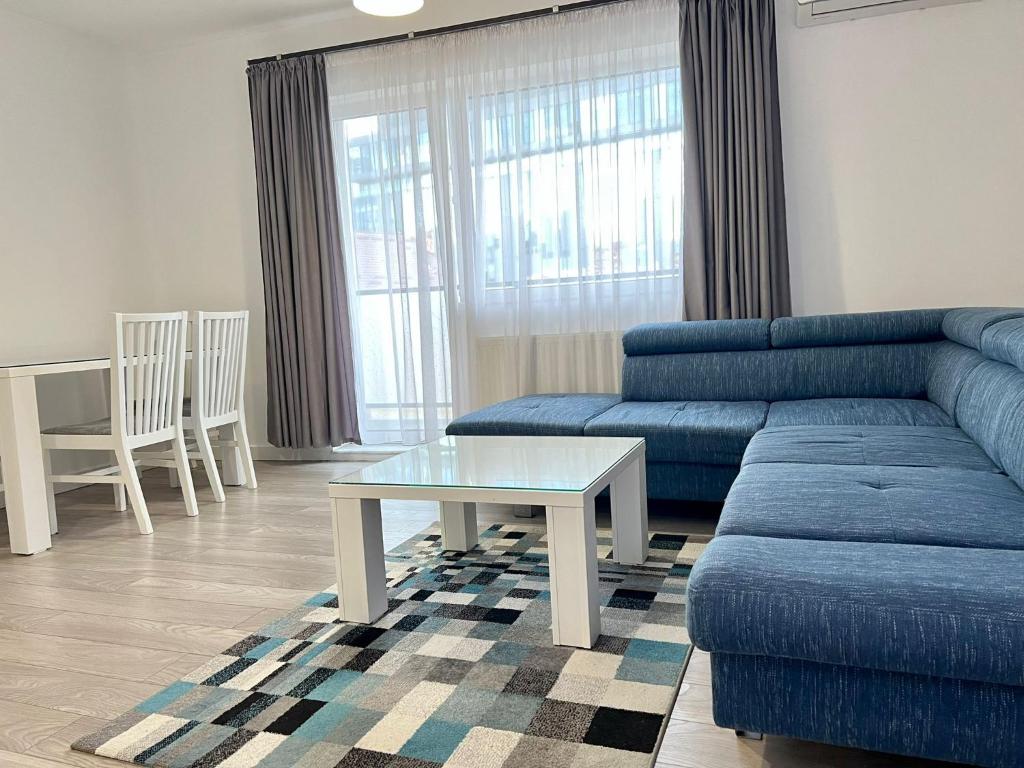 een woonkamer met een blauwe bank en een tafel bij Central cozy Apartment in Cluj-Napoca