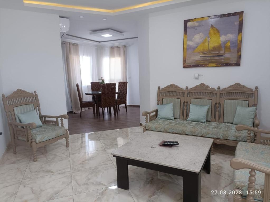 a living room with couches and a table and chairs at TIM Haute standing appartment S2, center Monastir in Monastir
