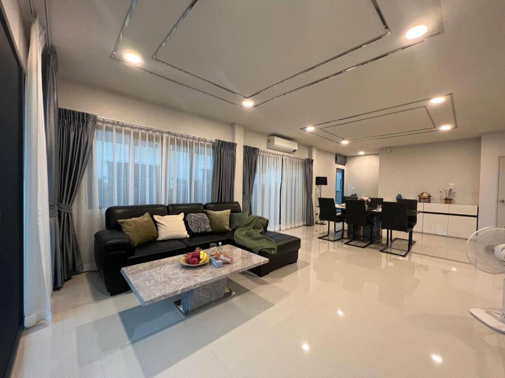 sala de estar con sofá y mesa en Cheri’s homestay现代两层独栋别墅，4卧4卫，3日送接机1周接送机,近Mega邦纳, en Bangkok