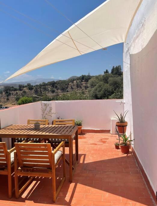 a patio with a table and chairs and a white canopy at Peaceful Townhouse Retreat in Órgiva