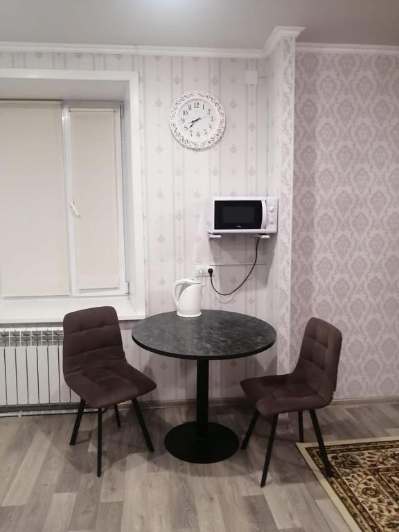 a dining room with a table and two chairs at Happy House in Karagandy