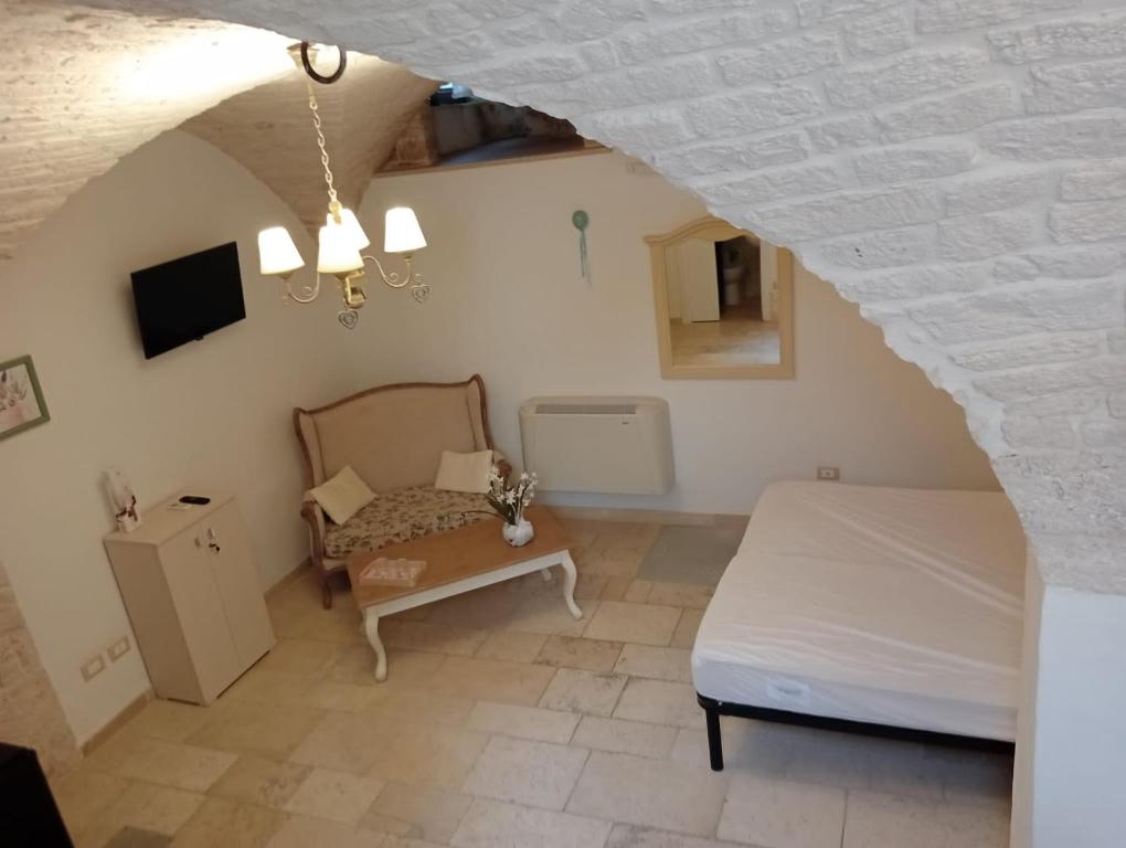 Schlafzimmer im Dachgeschoss mit einem Bett und einem Tisch in der Unterkunft Appartamento la Birba in Alberobello