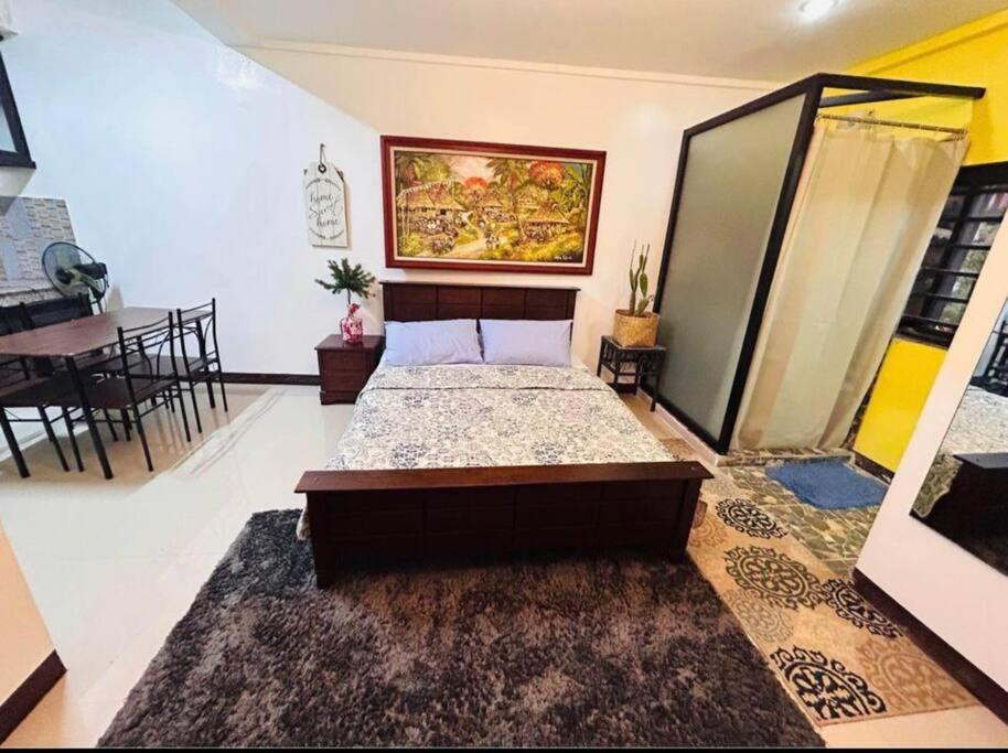 a bedroom with a bed and a dining room at Annie's in Tagaytay