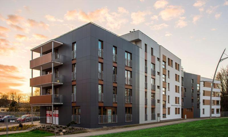 a gray building with balconies on the side of it at Apartament Głowackiego 10 in Koszalin