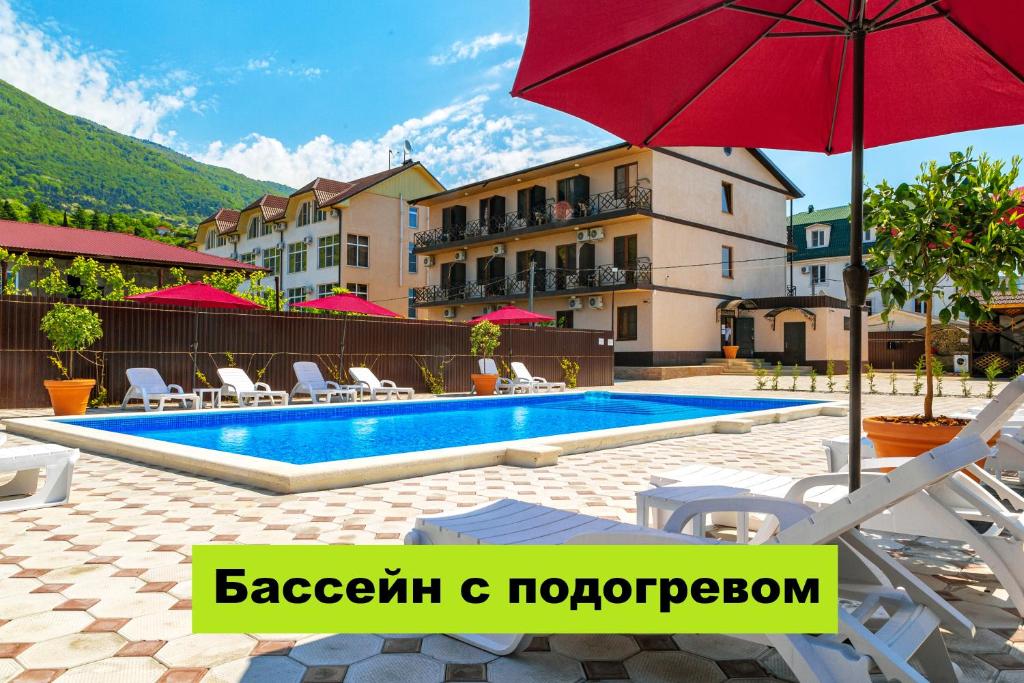 un hotel con piscina y sombrilla roja en Отель Taminik, en Gagra