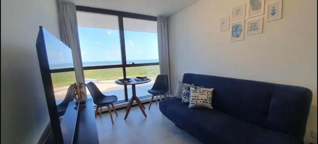 a living room with a blue couch and a table with chairs at BHF》1107•Conforto e tranquilidade. Flat beira mar! in Recife