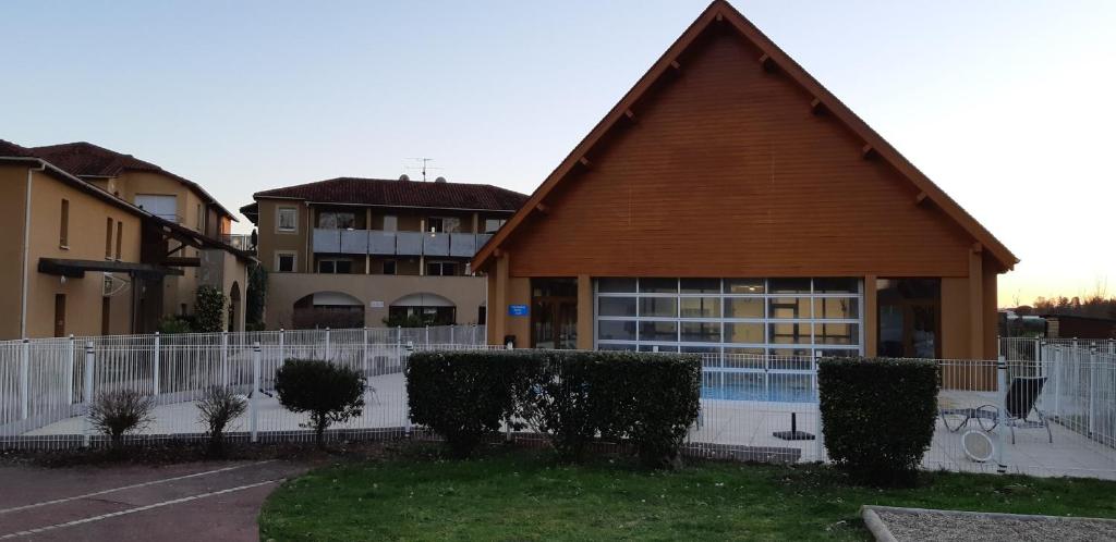 a building with a pool in front of a building at Charmant logement avec piscine in Bergerac