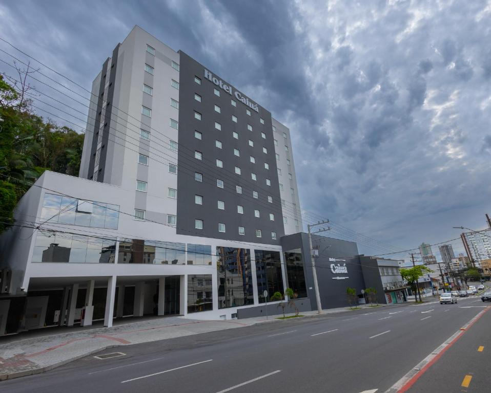 een groot gebouw aan de straatkant bij Hotel Caiuá Blumenau in Blumenau