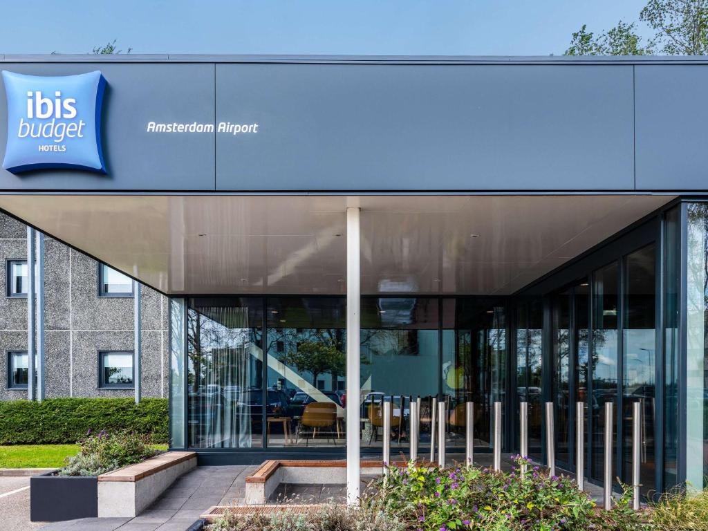 een kantoorgebouw met een blauw bord erop bij ibis budget Amsterdam Airport in Badhoevedorp