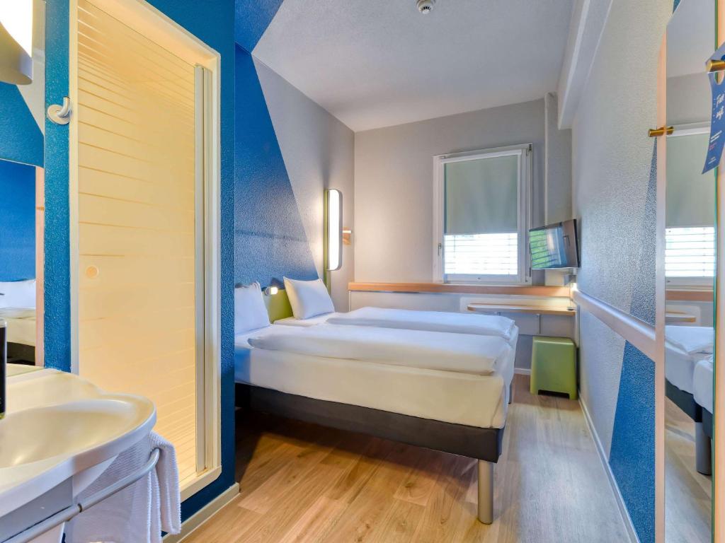 Pokój hotelowy z łóżkiem i umywalką w obiekcie ibis budget Hotel Luzern City w Lucernie