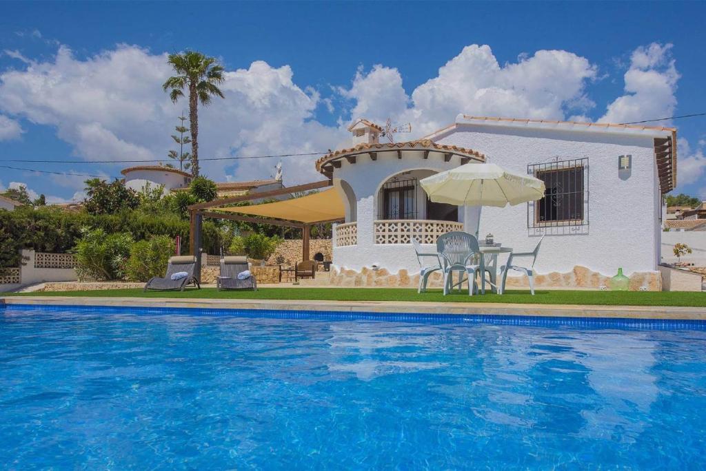 a villa with a swimming pool in front of a house at Villa Neus - PlusHolidays in Calpe