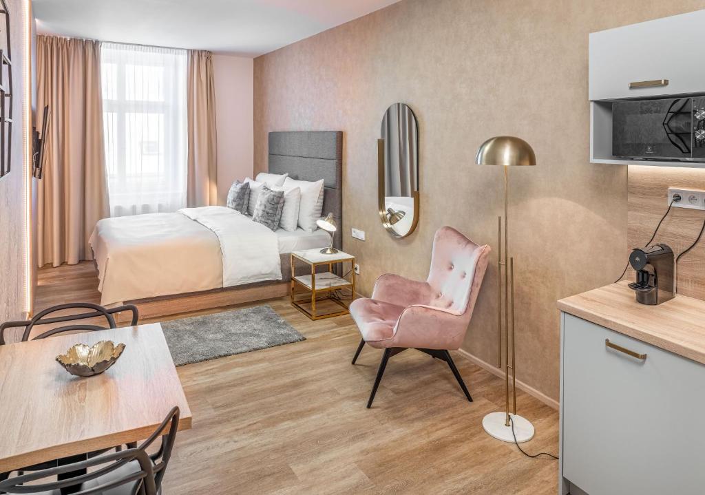 una camera d'albergo con letto, tavolo e sedia di Theatre 9 Apartments by Adrez a Praga