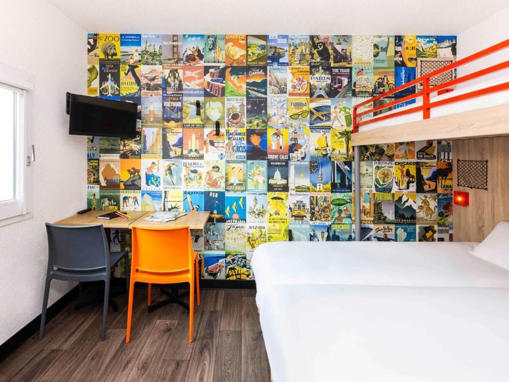 a room with a table and two chairs and a wall covered in photos at hotelF1 Dijon Nord in Dijon