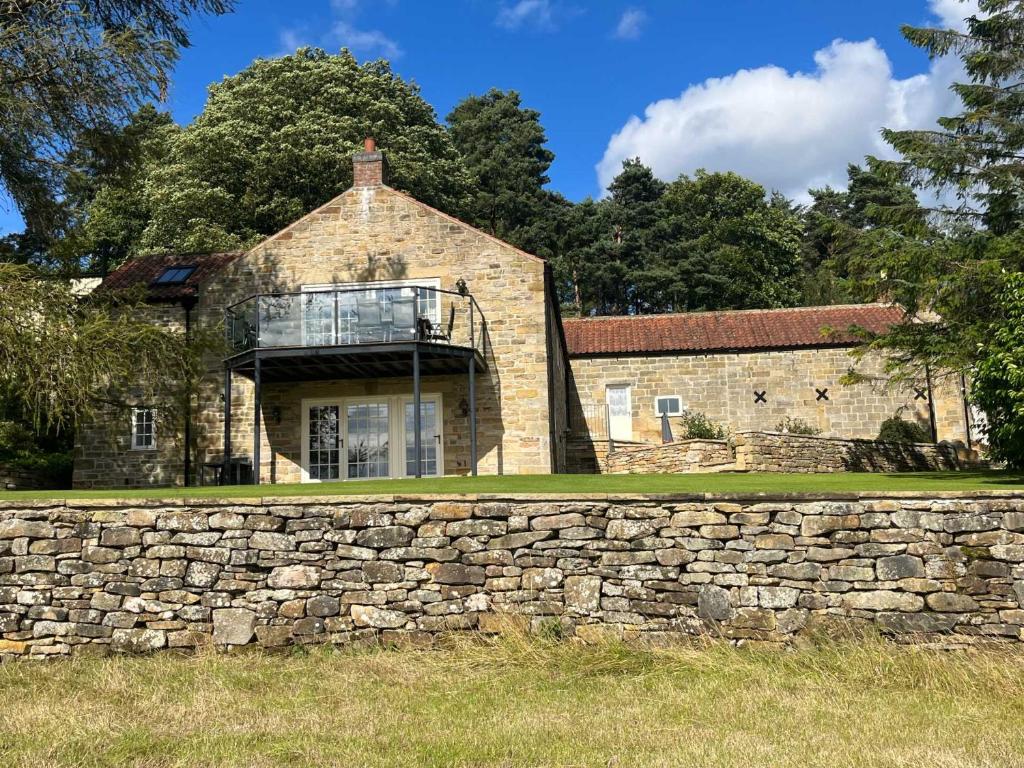 Rosedale AbbeyにあるThe Barn at Rigg Endのレンガ造りの建物前の石垣