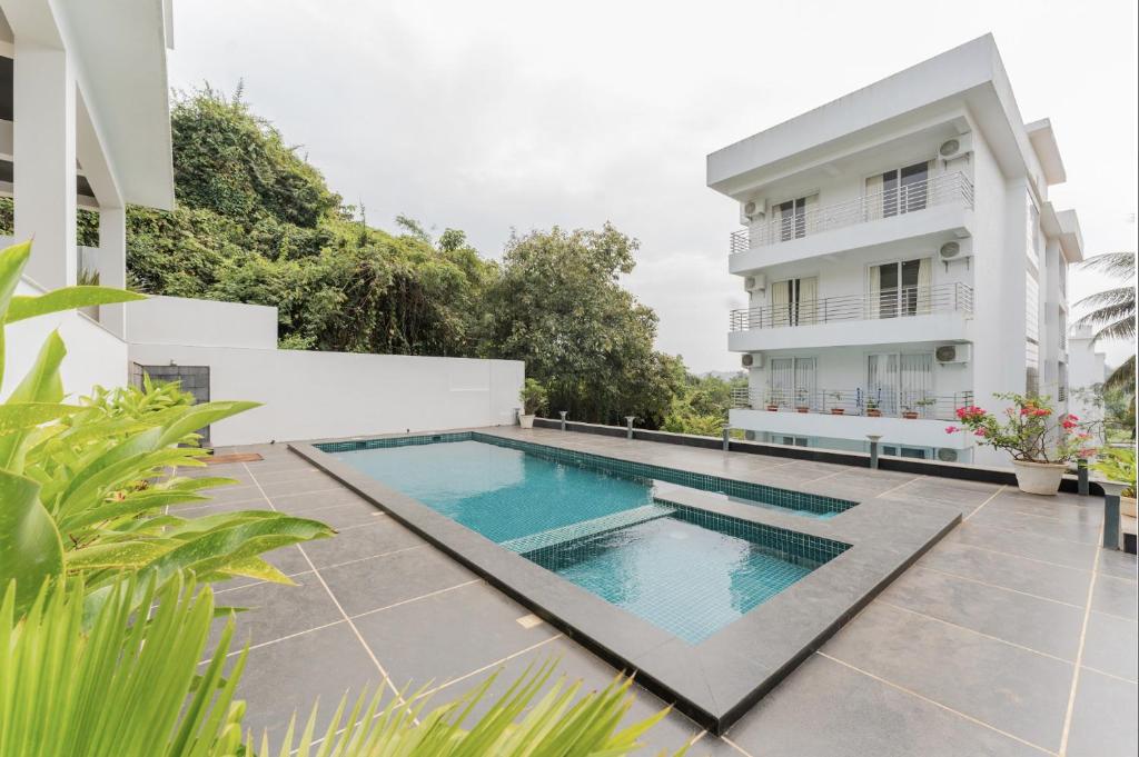 a swimming pool in front of a building at Lavish Apartments with Swimming Pool near Candolim Beach in Marmagao