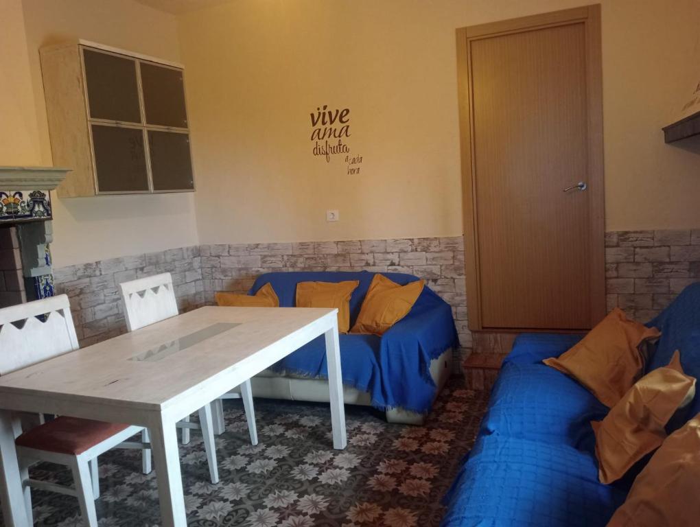 een woonkamer met een tafel en een bank bij An Ca La Abuela Pilar in El Real de la Jara