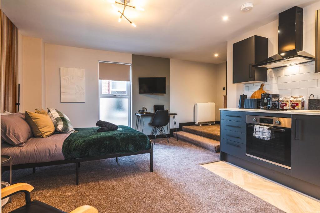 a living room with a bed and a kitchen at Luxury Central Derby Apartment in Derby