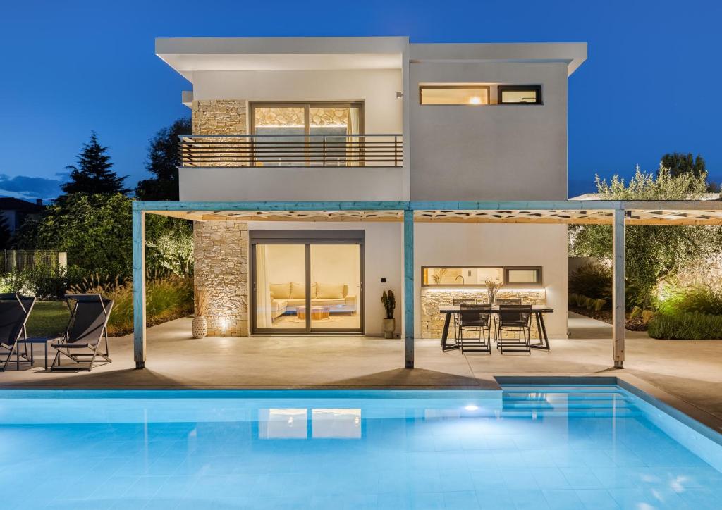 a house with a swimming pool in front of it at White Nest Villas in Litochoro